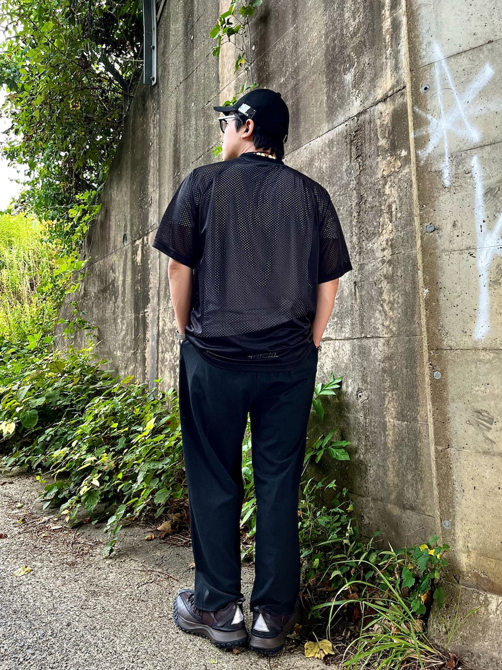ブラック系のスニーカー、ブラック系のスラックス、ブラック系のTシャツ/カットソーを着用したメンズの夏コーディネートの2枚目の写真