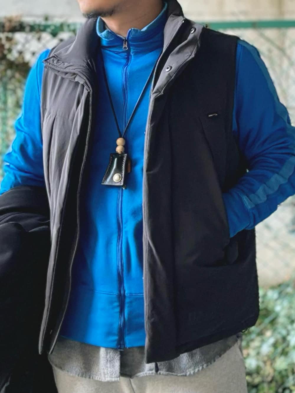 ブラック系のステンカラーコート、ブラック系のモカシン/デッキシューズ、グレー系のスウェットパンツを着用したメンズの冬コーディネートの4枚目の写真