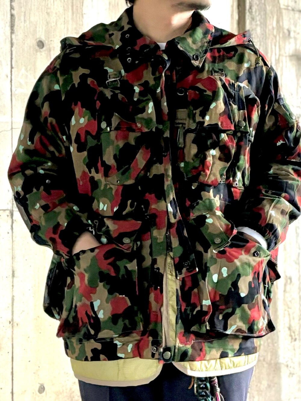 イエロー系のスニーカー、ブルー系のスラックス、その他のミリタリージャケットを着用したメンズの冬コーディネートの3枚目の写真