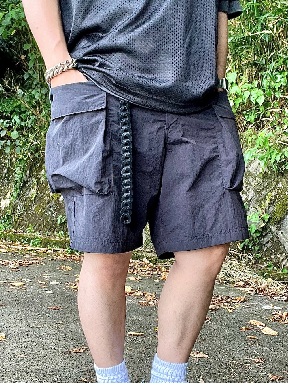 ホワイト系のスニーカー、ブラック系のカーゴパンツ、ブラック系のTシャツ/カットソーを着用したメンズの夏コーディネートの3枚目の写真