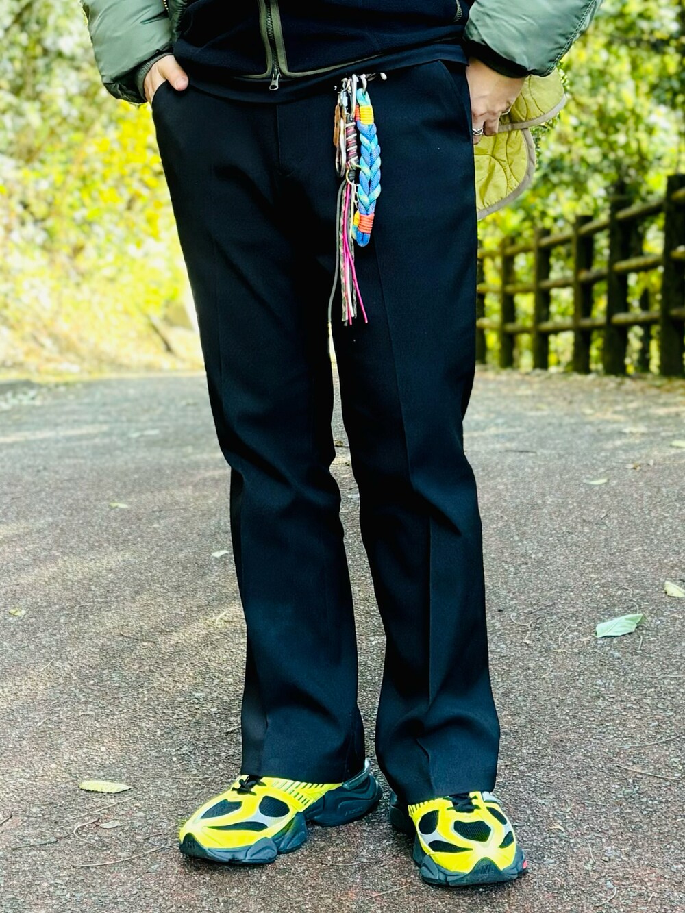 イエロー系のスニーカー、ブラック系のスラックス、グリーン系のMA-1を着用したメンズの冬コーディネートの3枚目の写真