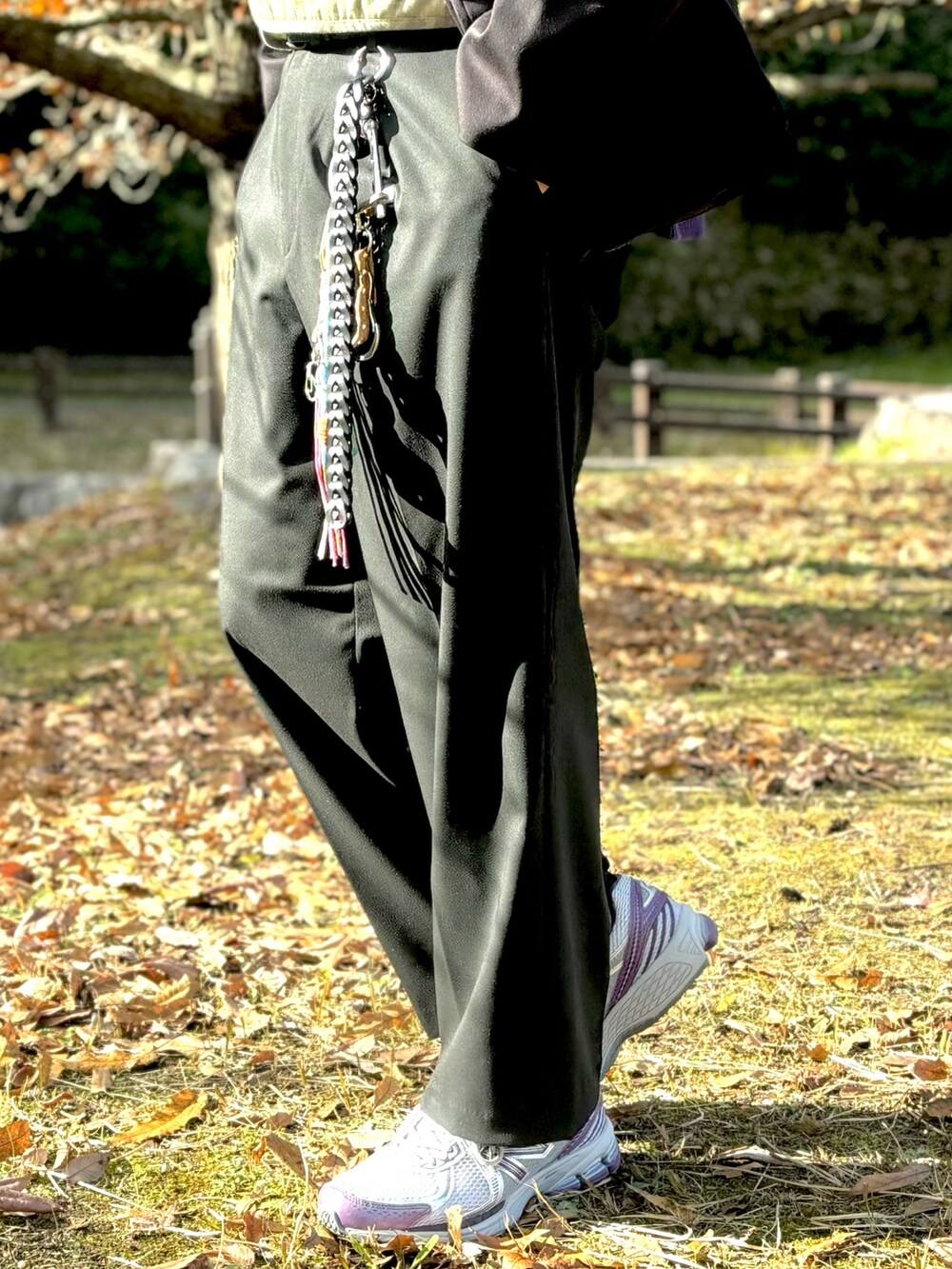 パープル系のスニーカー、ブラック系のスラックス、ブラック系のミリタリージャケットを着用したメンズの冬コーディネートの5枚目の写真