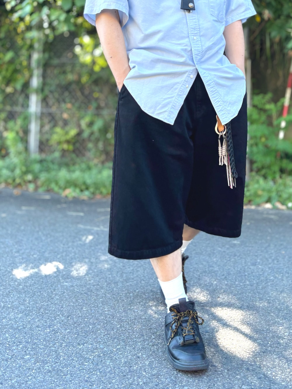 ブラック系のデニムパンツ、ブラック系のスニーカー、ブルー系のシャツ/ブラウスを着用したメンズの夏コーディネートの2枚目の写真