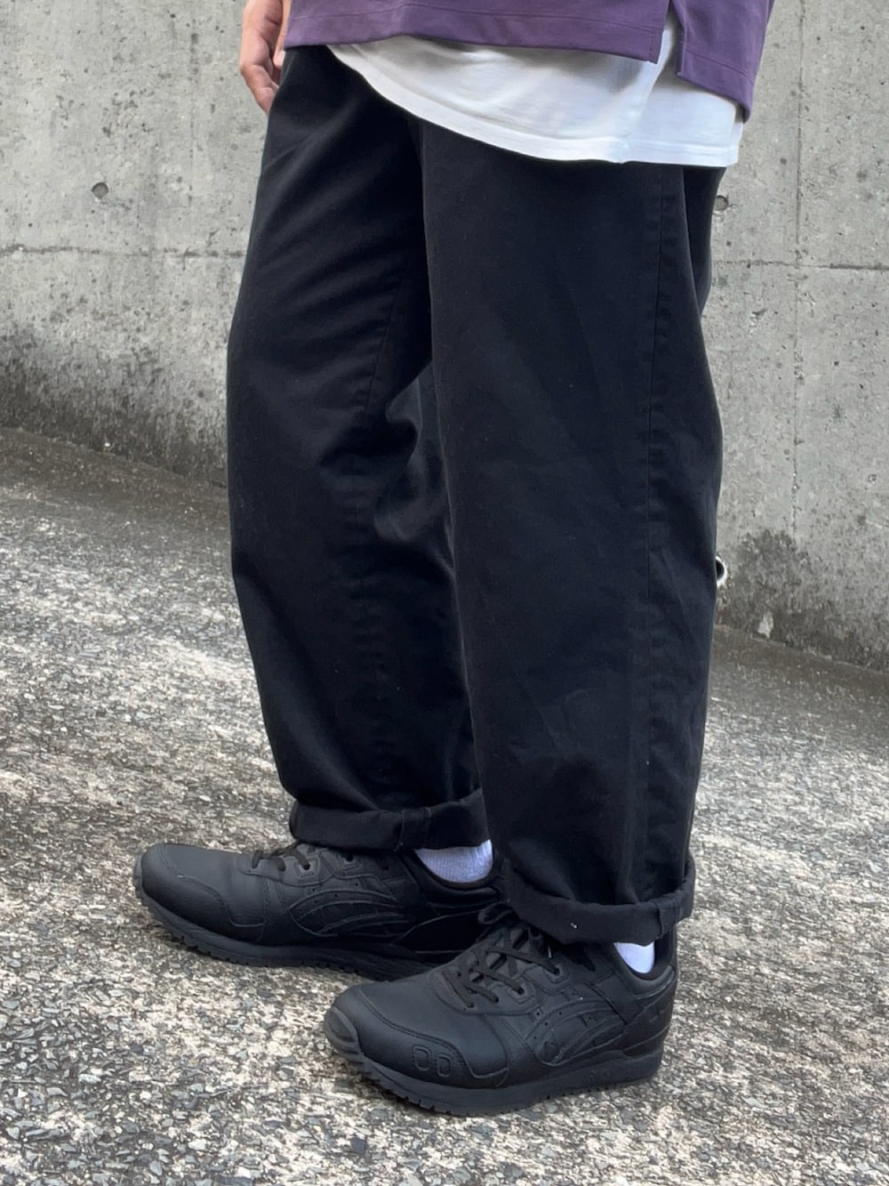 ブラック系のスニーカー、ブラック系のチノパンツ、ブラック系のベストを着用したメンズの夏コーディネートの4枚目の写真