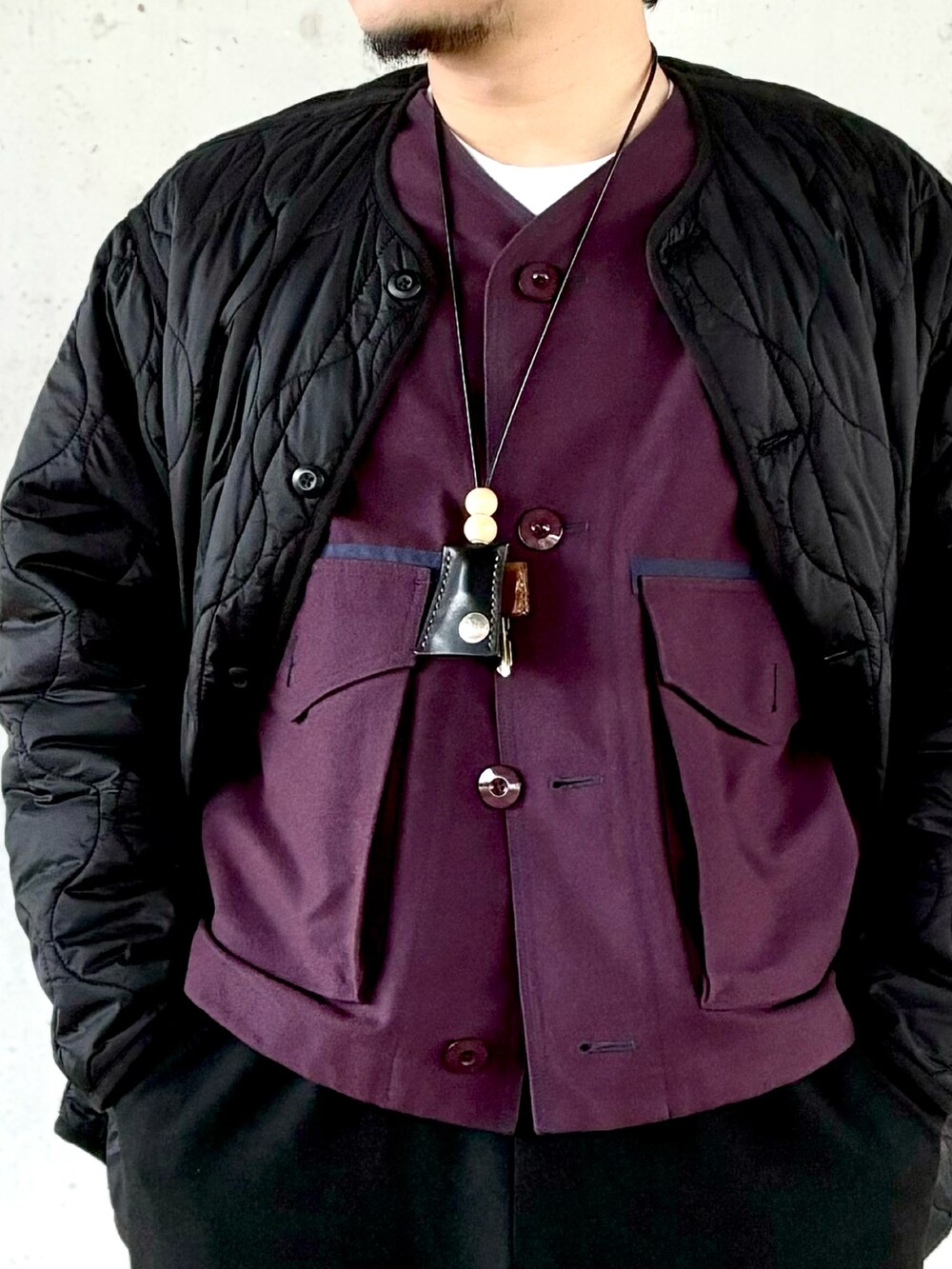 パープル系のスニーカー、ブラック系のスラックス、パープル系のブルゾンを着用したメンズの秋コーディネートの2枚目の写真