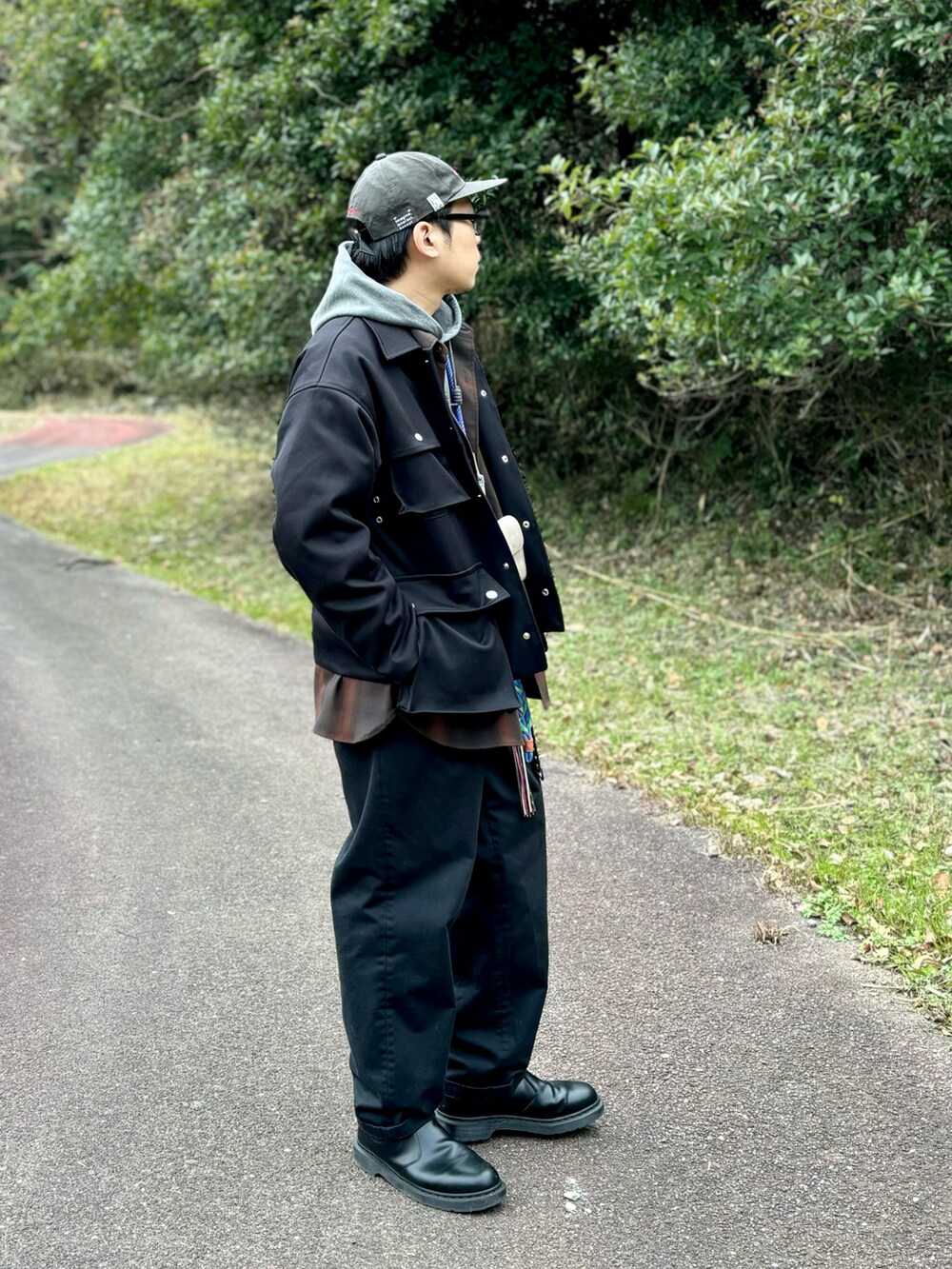 ブラック系のブーツ、ブラック系のチノパンツ、ブラック系のミリタリージャケットを着用したメンズの冬コーディネートの2枚目の写真