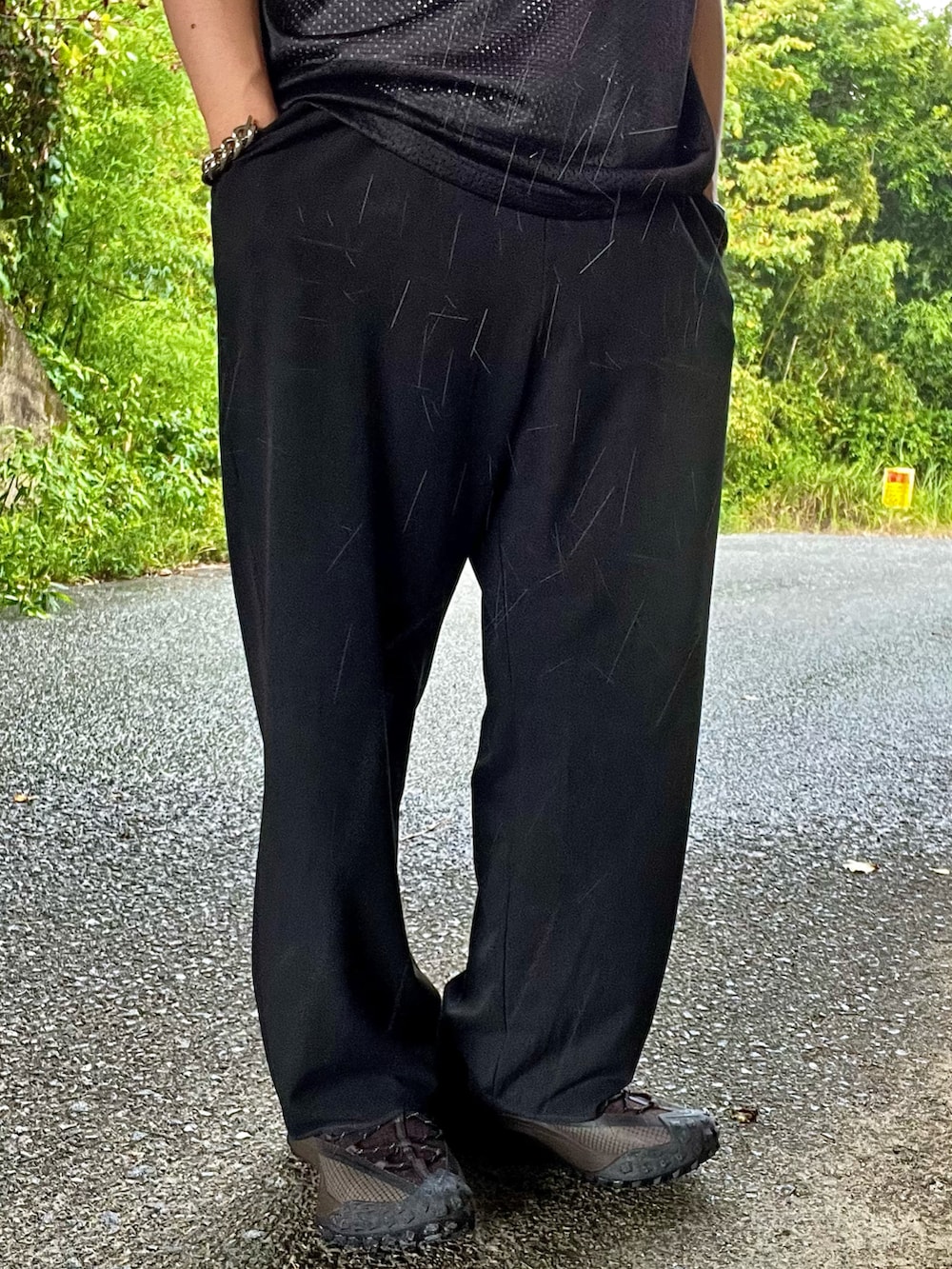 ブラック系のスニーカー、ブラック系のスラックス、ブラック系のTシャツ/カットソーを着用したメンズの夏コーディネートの3枚目の写真