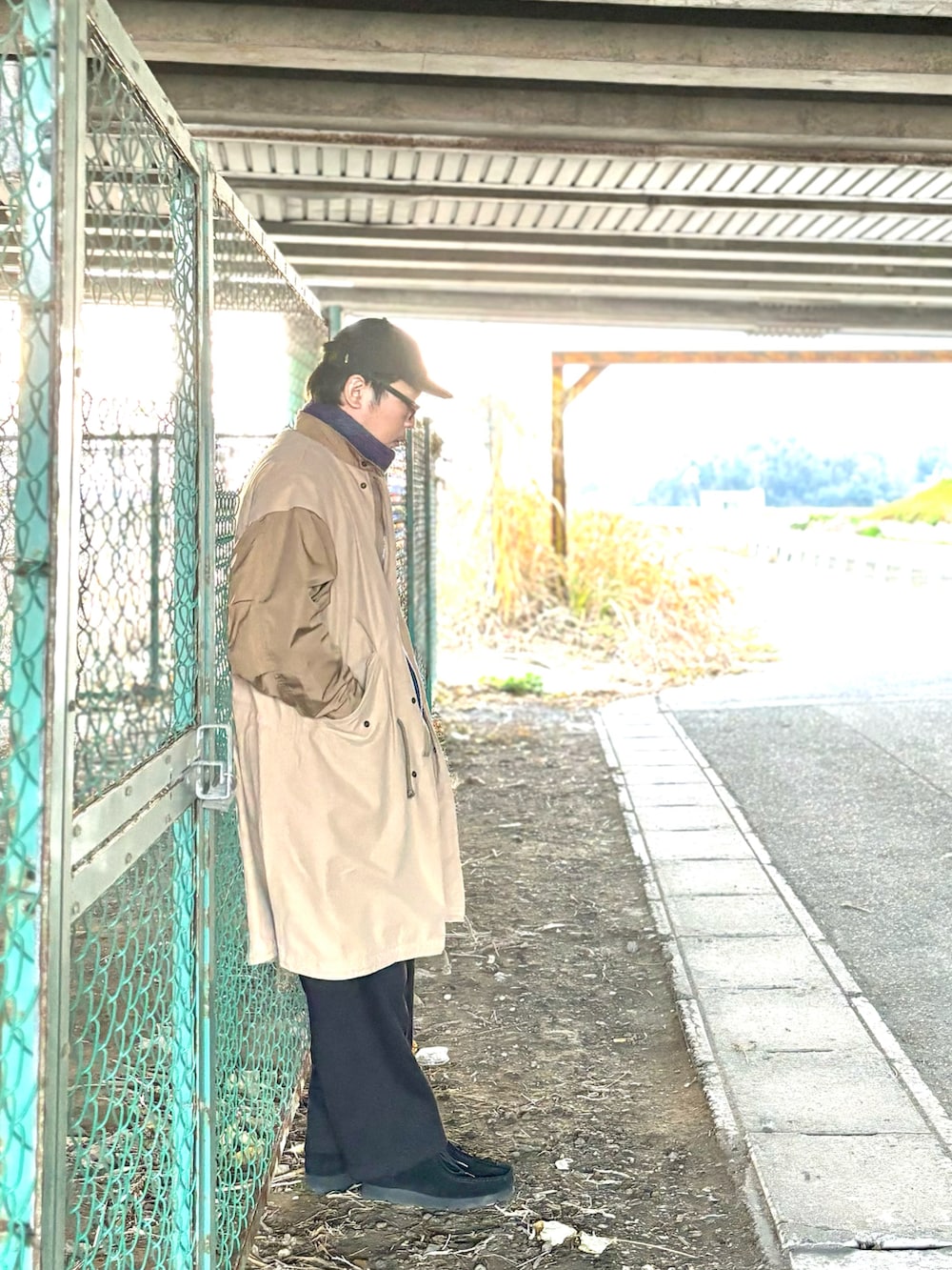 ブラック系のモカシン/デッキシューズ、ブラック系のスウェットパンツ、ブラウン系のモッズコートを着用したメンズの冬コーディネートの5枚目の写真