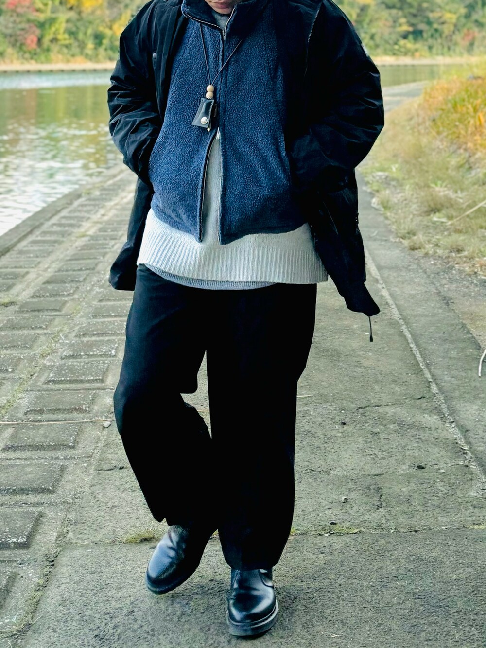 ブルー系のベスト、ブラック系のジャケット/アウター、グレー系のニット/セーターを着用したメンズの冬コーディネートの2枚目の写真