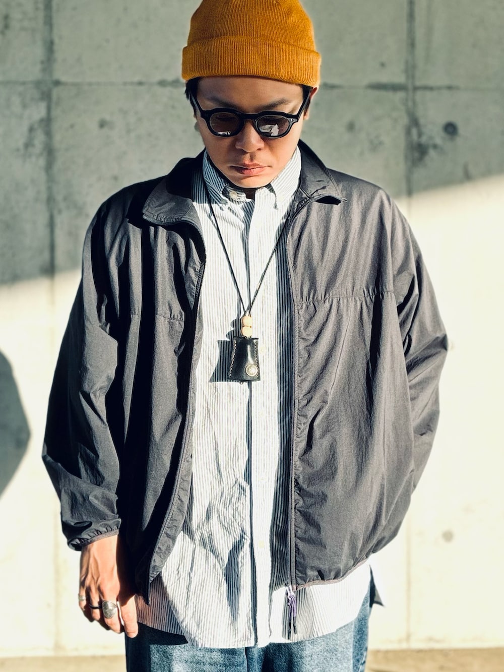 ブラック系のスニーカー、ブルー系のデニムパンツ、ブルー系のシャツ/ブラウスを着用したメンズの秋コーディネートの3枚目の写真