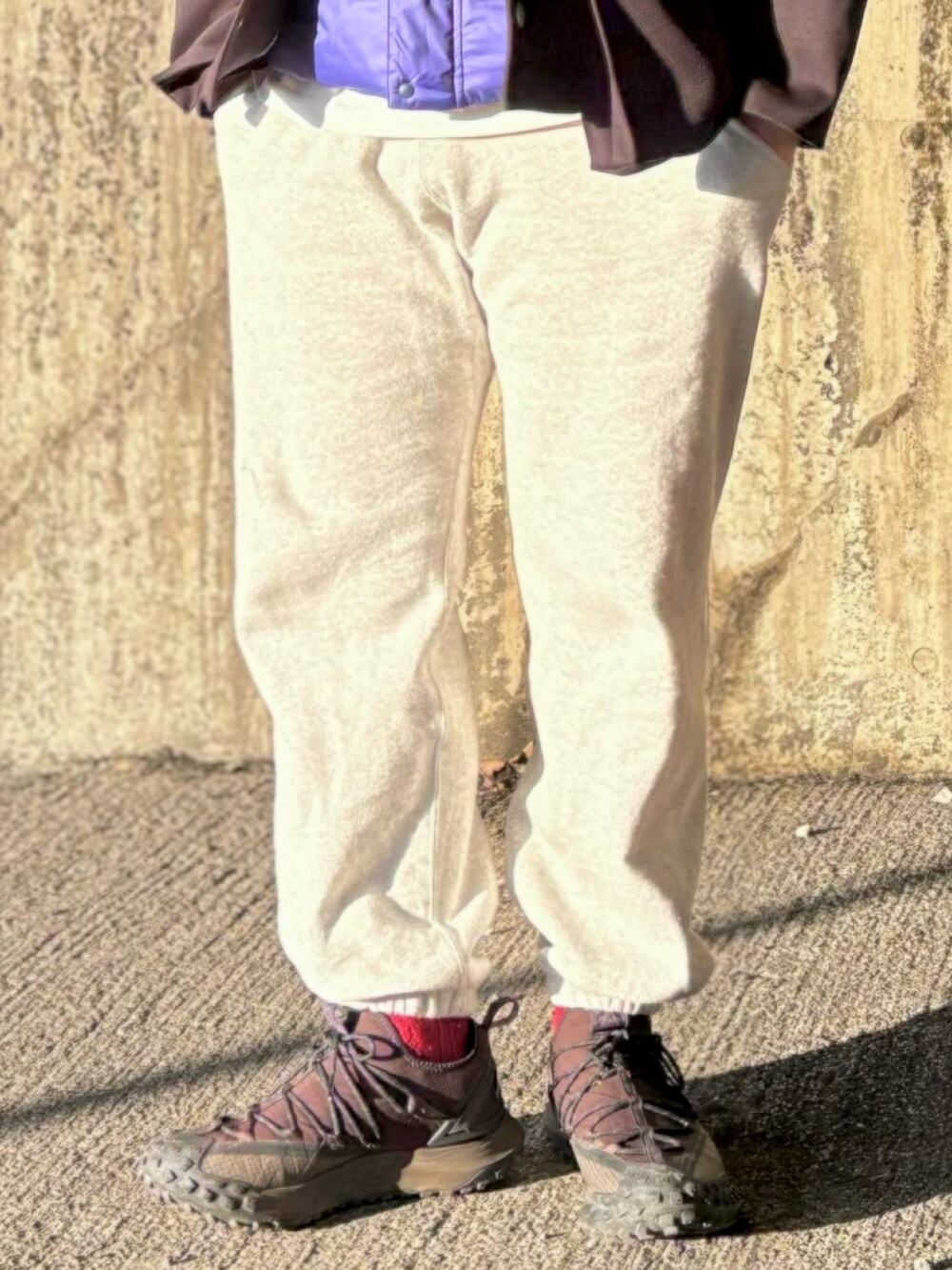 ブラック系のスニーカー、グレー系のスウェットパンツ、パープル系のベストを着用したメンズの冬コーディネートの3枚目の写真