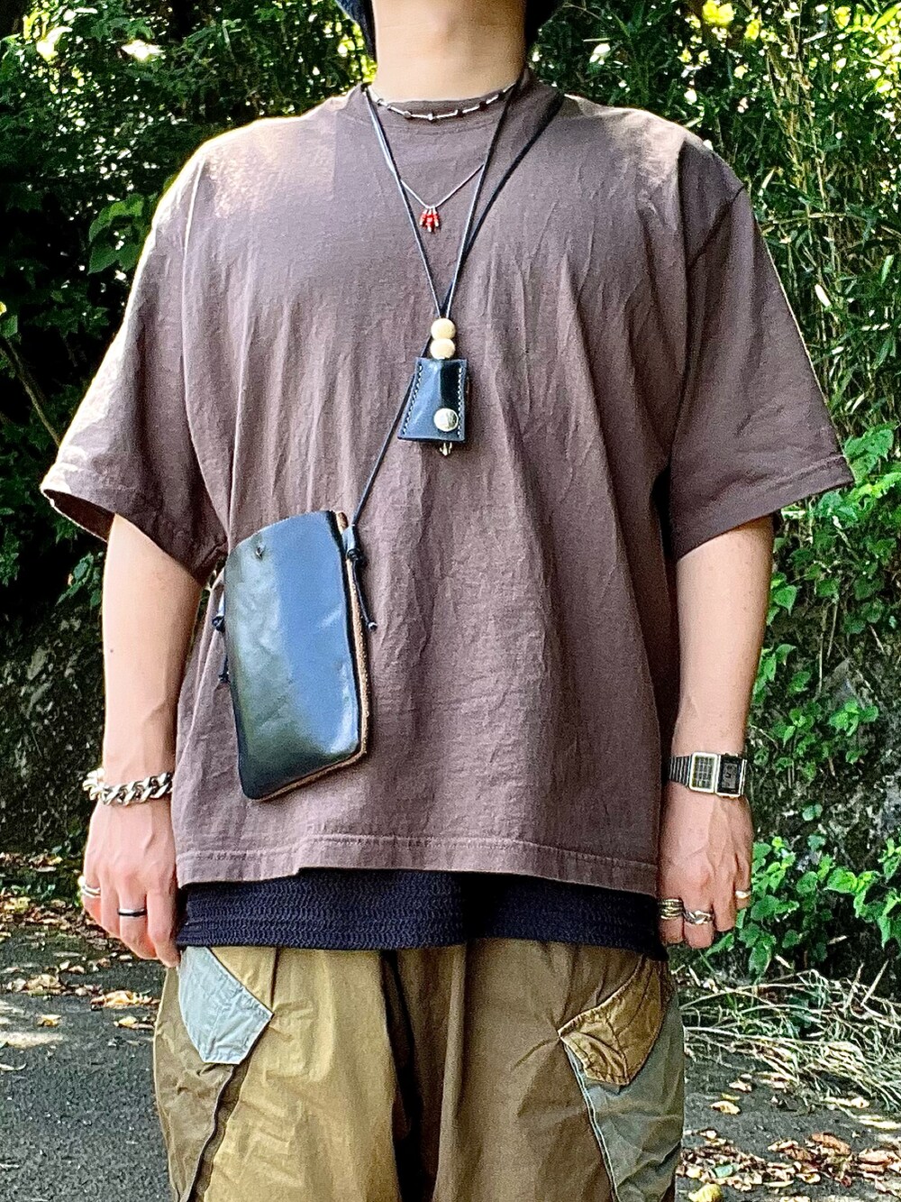 ベージュ系のサンダル、グリーン系のカーゴパンツ、ブラック系のタンクトップを着用したメンズの夏コーディネートの2枚目の写真