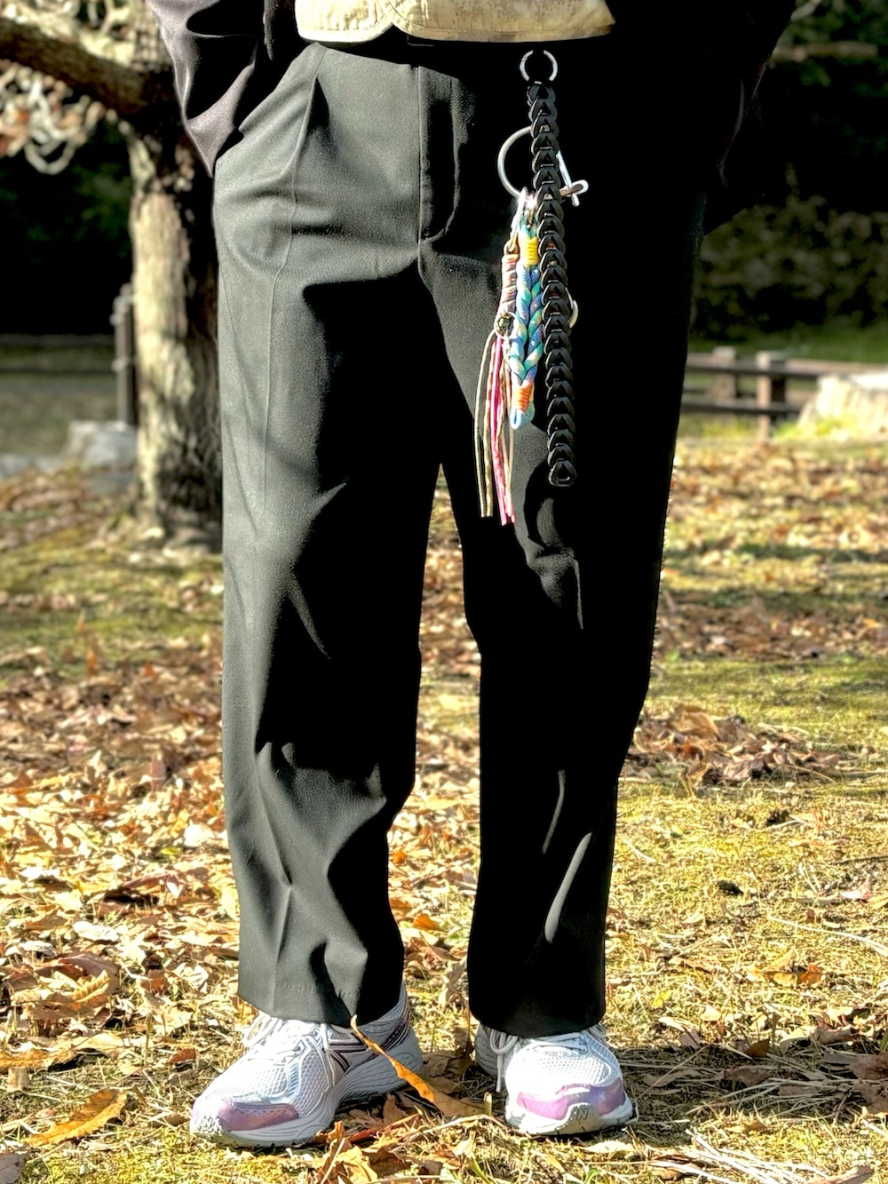 パープル系のスニーカー、ブラック系のスラックス、ブラック系のミリタリージャケットを着用したメンズの冬コーディネートの4枚目の写真