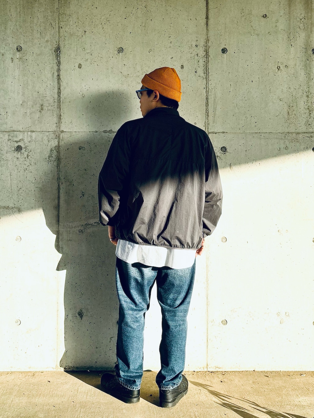 ブラック系のスニーカー、ブルー系のデニムパンツ、ブルー系のシャツ/ブラウスを着用したメンズの秋コーディネートの2枚目の写真