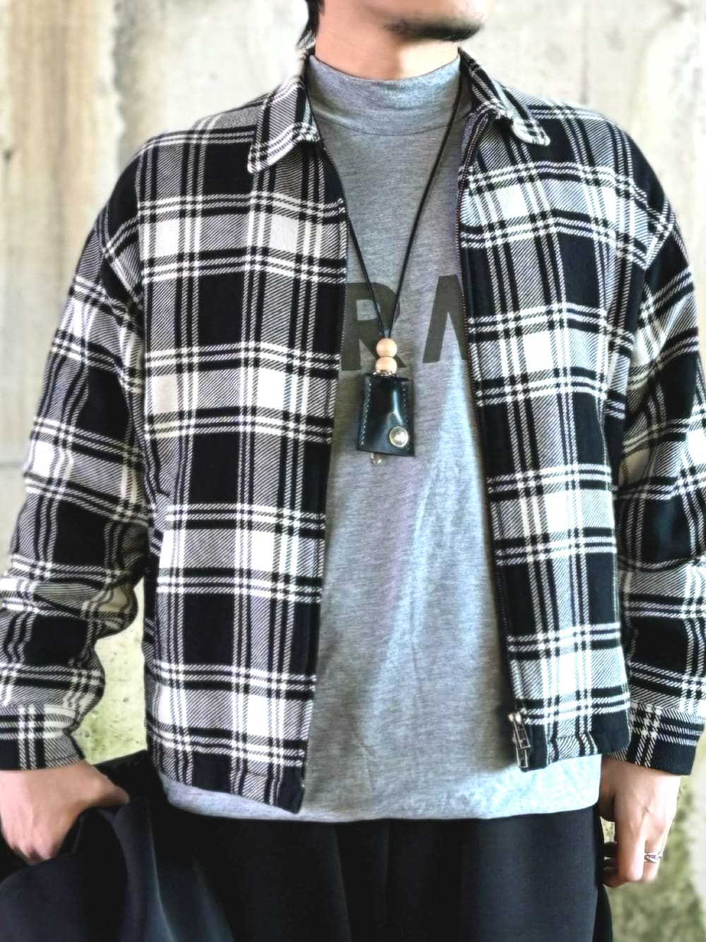 ブラック系のミリタリージャケット、グレー系のTシャツ/カットソー、ブラック系のブルゾンを着用したメンズの冬コーディネートの4枚目の写真