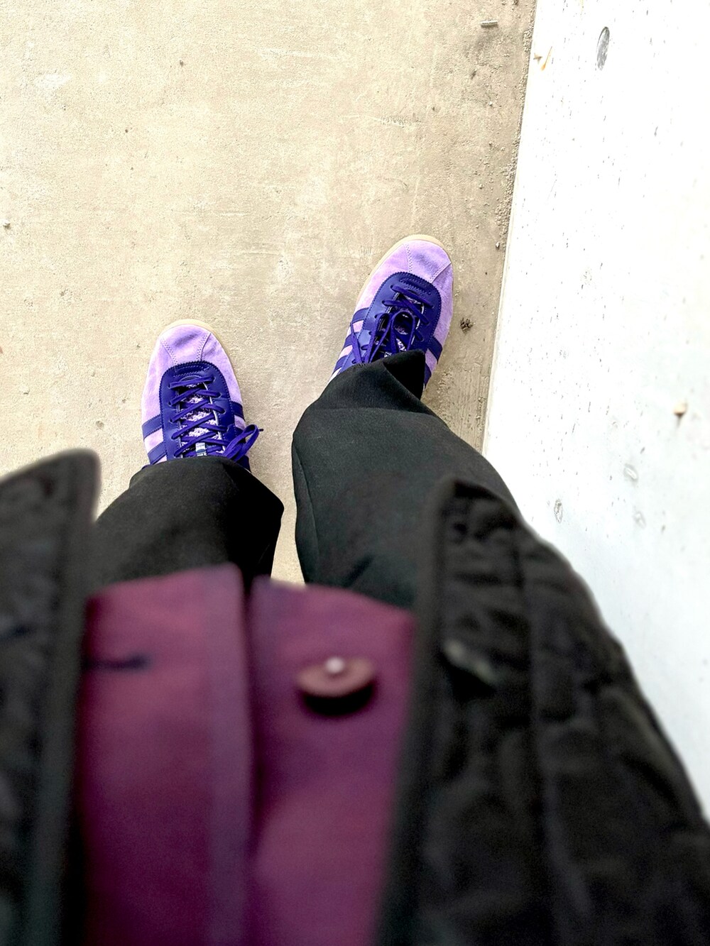 パープル系のスニーカー、ブラック系のスラックス、パープル系のブルゾンを着用したメンズの秋コーディネートの4枚目の写真