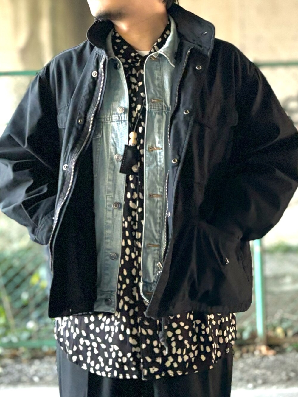 ブラック系のモカシン/デッキシューズ、ブラック系のスラックス、ブラック系のブルゾンを着用したメンズの冬コーディネートの3枚目の写真