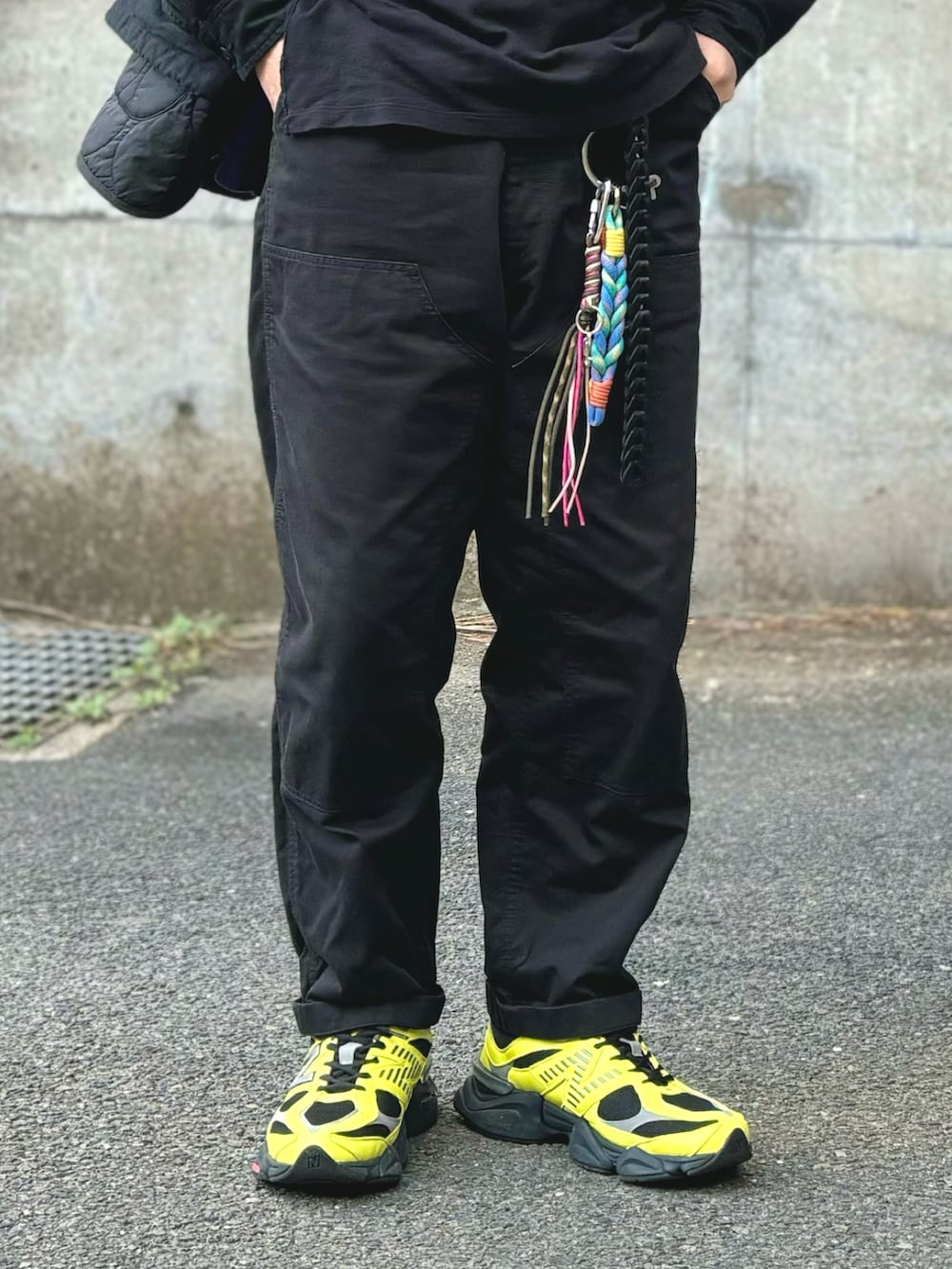 イエロー系のスニーカー、ブラック系のその他パンツ、ブラック系のTシャツ/カットソーを着用したメンズの冬コーディネートの5枚目の写真