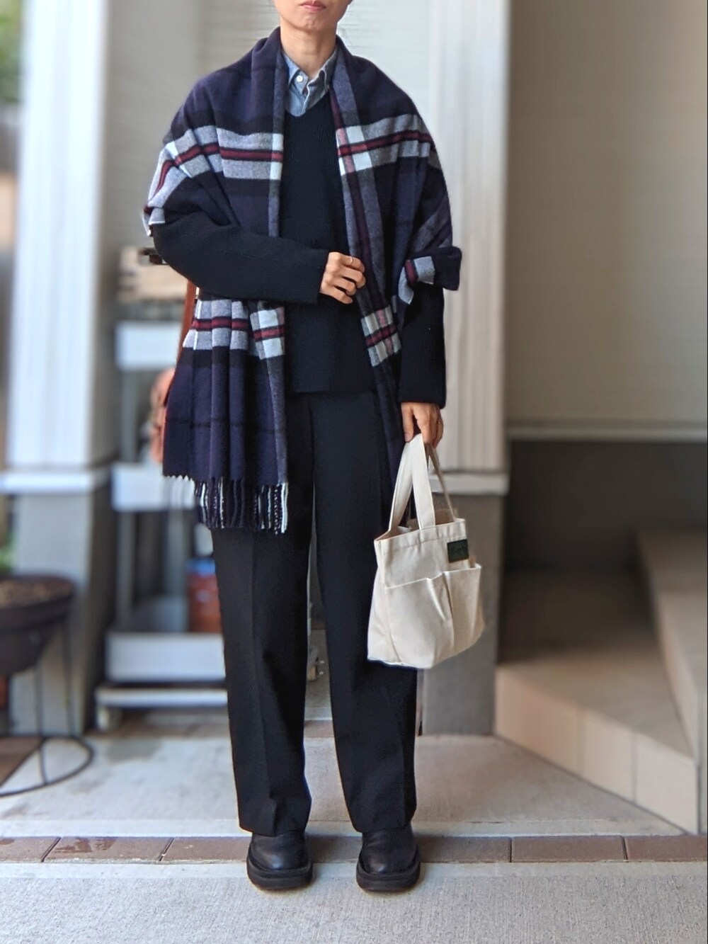 オレンジ系のショルダーバッグ、ブラック系のパンツ、ブラック系のブーツを着用したレディースの秋コーディネートの2枚目の写真