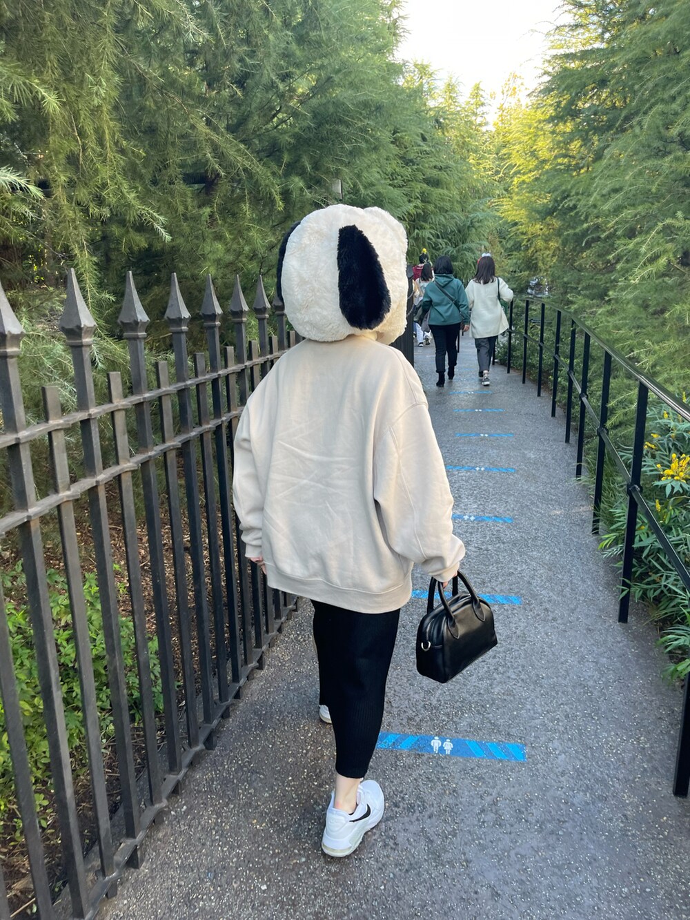 ブラック系のバッグ、ホワイト系のスニーカー、ベージュ系のスウェットを着用したレディースの秋コーディネートの2枚目の写真