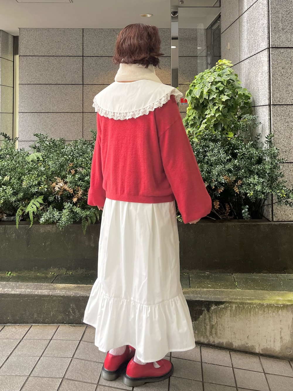 レッド系のカーディガン/ボレロ、ホワイト系のワンピース、レッド系のバレエシューズを着用したレディースの秋コーディネートの2枚目の写真
