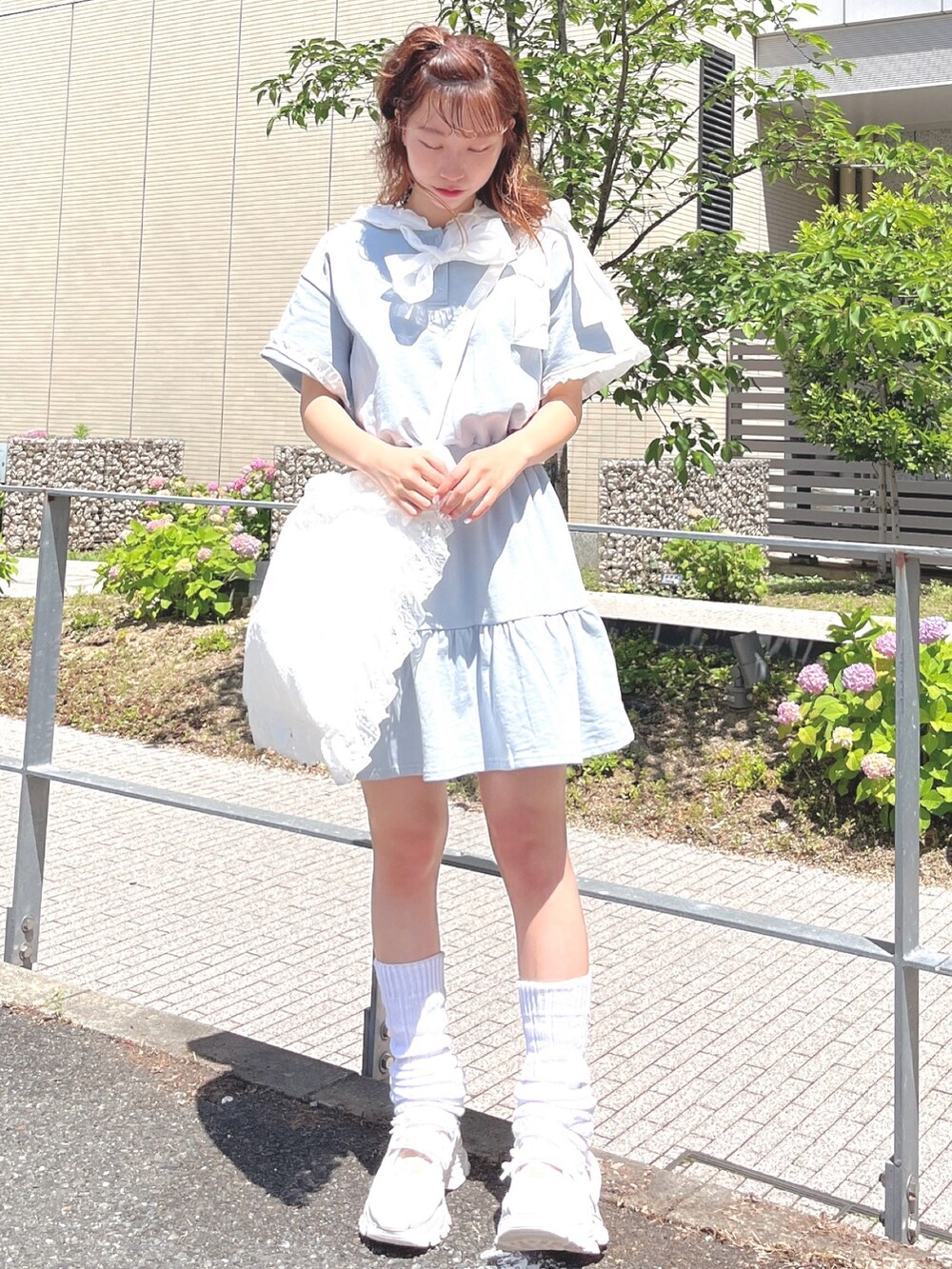 ブルー系のワンピース、ホワイト系のトートバッグ、ホワイト系のスニーカーを着用したレディースの夏コーディネートの2枚目の写真