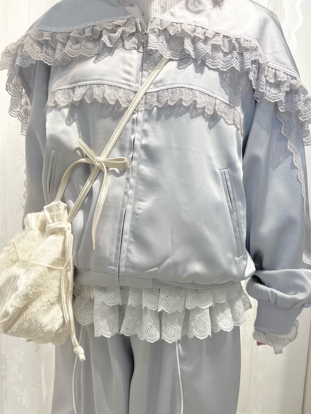 ブルー系のその他パンツ、グレー系のブルゾン、ホワイト系のショルダーバッグを着用したレディースの春コーディネートの6枚目の写真