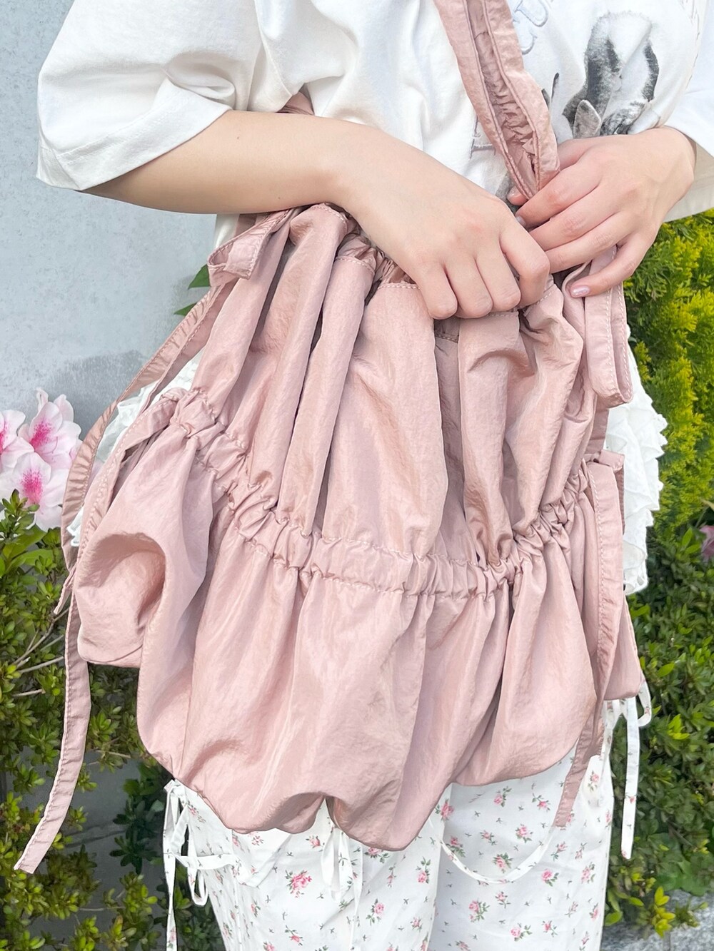 ホワイト系のTシャツ/カットソー、ホワイト系のスラックス、ピンク系のトートバッグを着用したレディースの春コーディネートの9枚目の写真