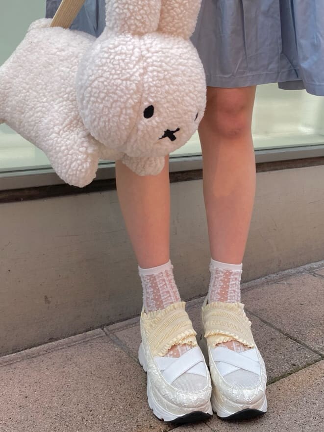 ホワイト系のスニーカー、ブルー系のワンピース、ホワイト系のハンドバッグを着用したレディースの夏コーディネートの4枚目の写真
