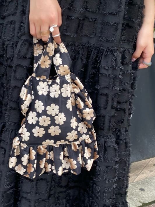 ブラック系のワンピース、ブラック系のパンプス、その他のハンドバッグを着用したレディースの秋コーディネートの5枚目の写真