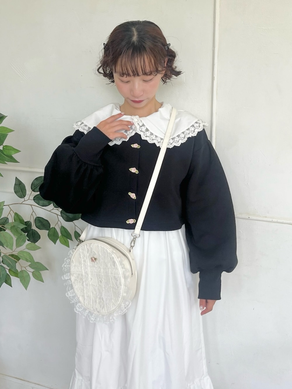 ホワイト系のワンピース、ブラック系のカーディガン/ボレロ、ホワイト系のショルダーバッグを着用したレディースの秋コーディネートの4枚目の写真