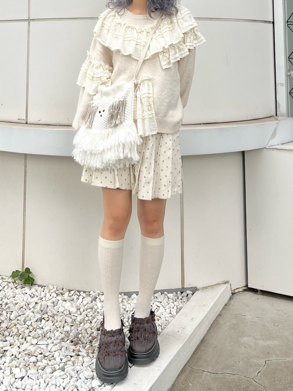 ホワイト系のニット/セーター、ホワイト系のスカート、ベージュ系のショルダーバッグを着用したレディースの秋コーディネートの4枚目の写真