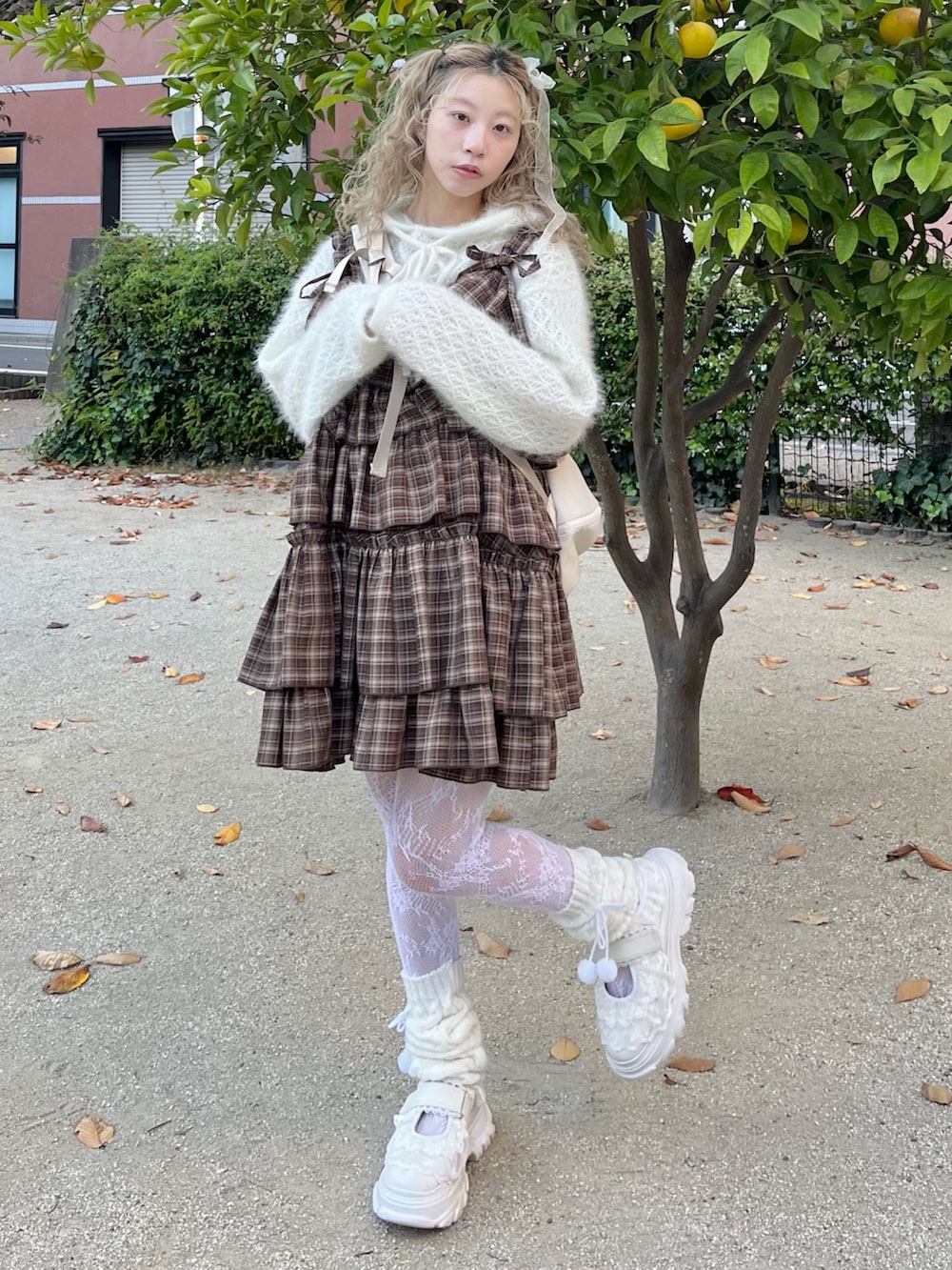 ホワイト系のニット/セーター、ブラウン系のワンピース、ベージュ系のショルダーバッグを着用したレディースの秋コーディネートの2枚目の写真