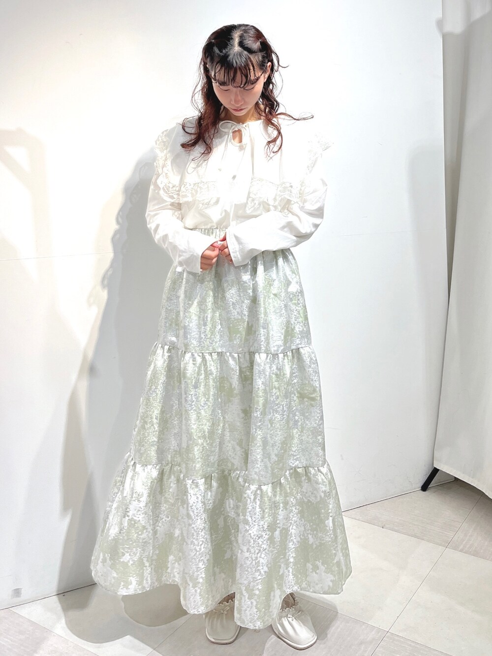 ホワイト系のTシャツ/カットソー、グリーン系のスカート、ホワイト系のパンプスを着用したレディースの冬コーディネートの2枚目の写真