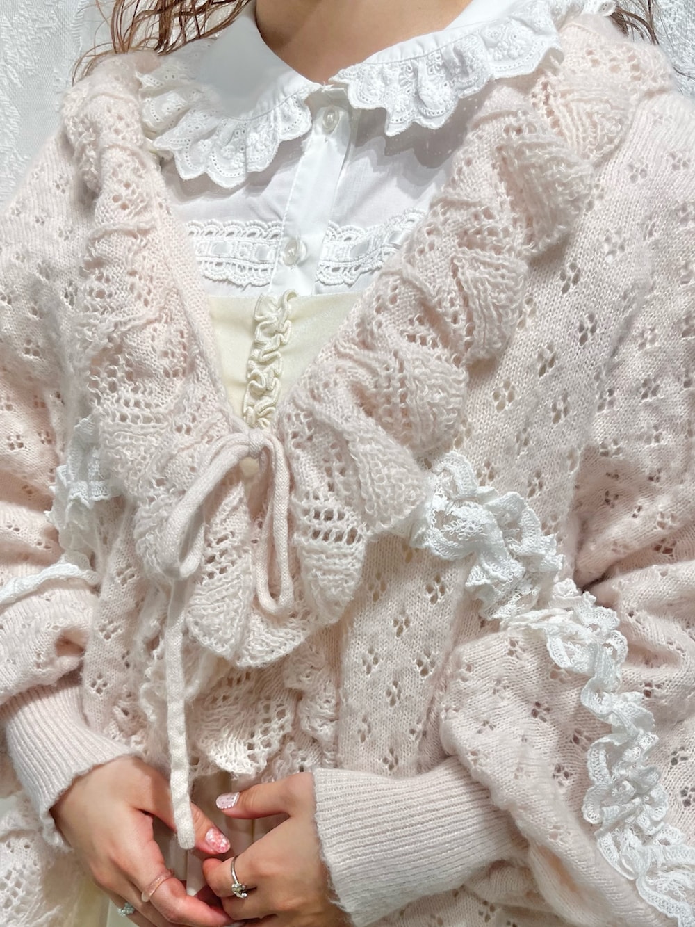 ピンク系のニット/セーター、ホワイト系のワンピース、ホワイト系のシャツ/ブラウスを着用したレディースの春コーディネートの9枚目の写真