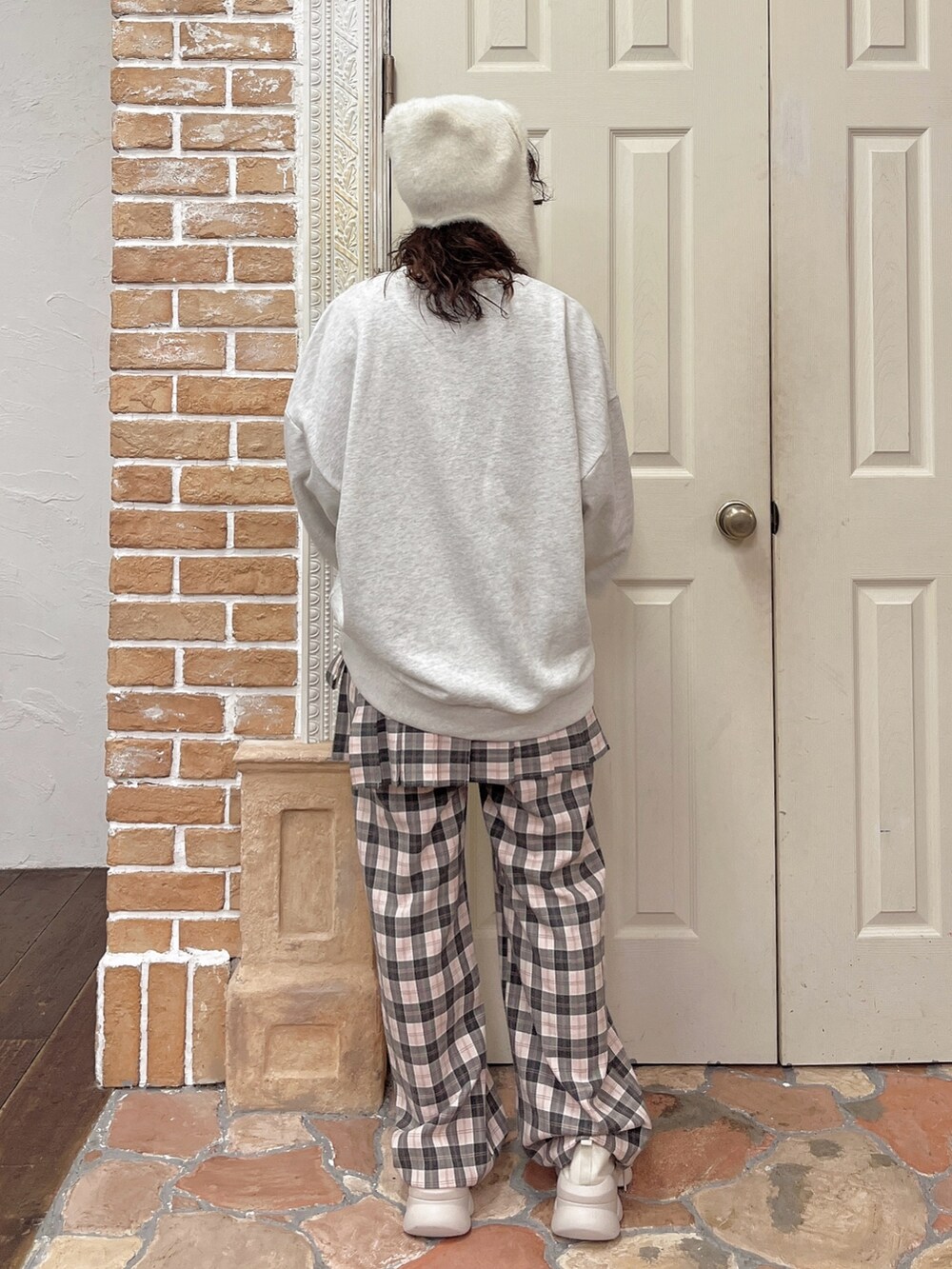 ピンク系のスラックス、グレー系のスウェット、ホワイト系のスニーカーを着用したレディースの夏コーディネートの3枚目の写真