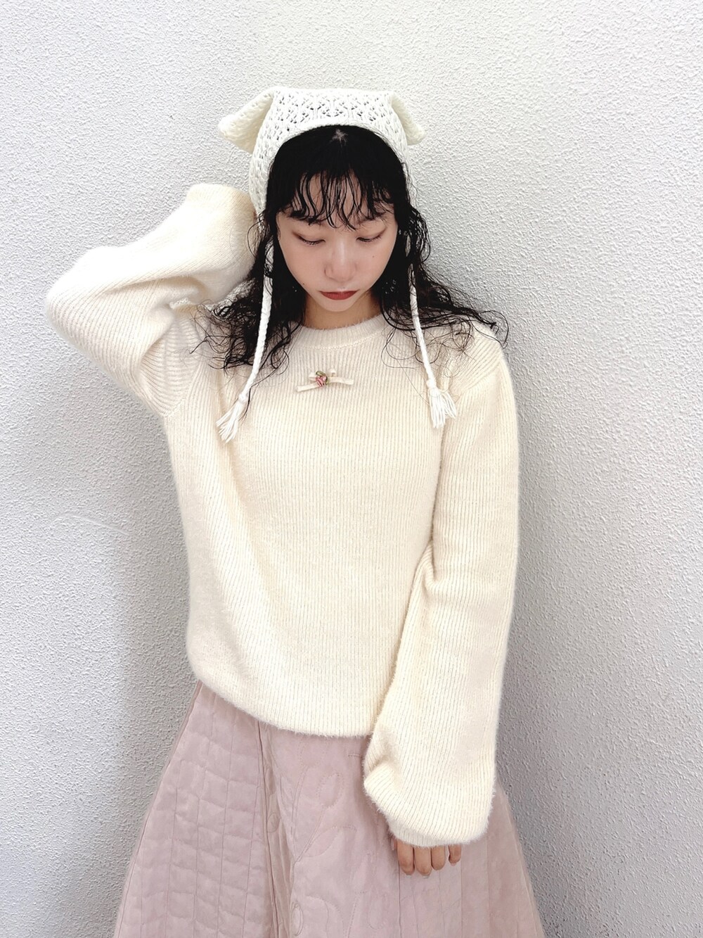 ホワイト系のニット/セーター、ピンク系のスカート、ホワイト系のブーツを着用したレディースの秋コーディネートの4枚目の写真