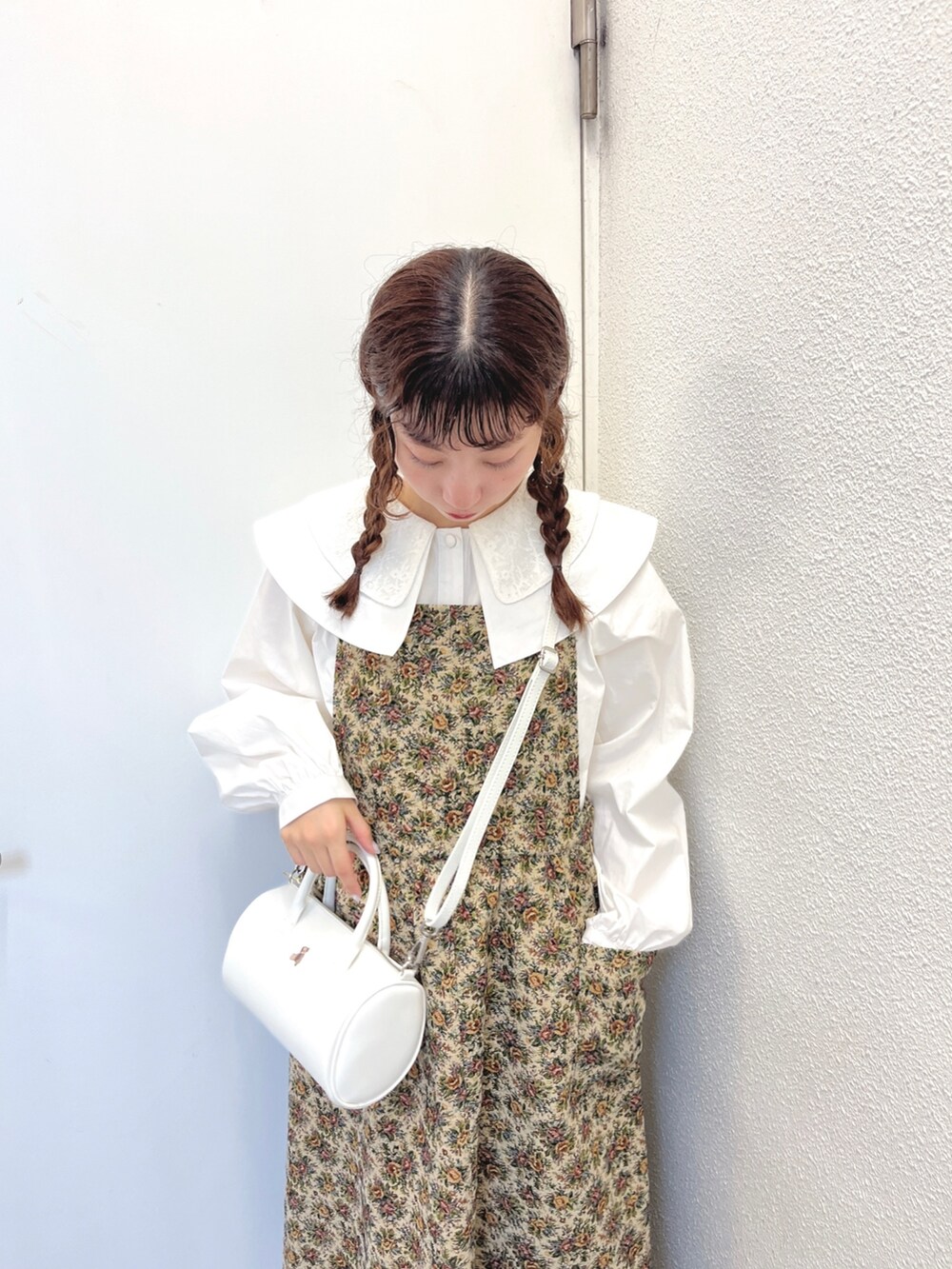 ベージュ系のジャンパースカート、ホワイト系のハンドバッグ、ホワイト系のサンダルを着用したレディースの秋コーディネートの5枚目の写真