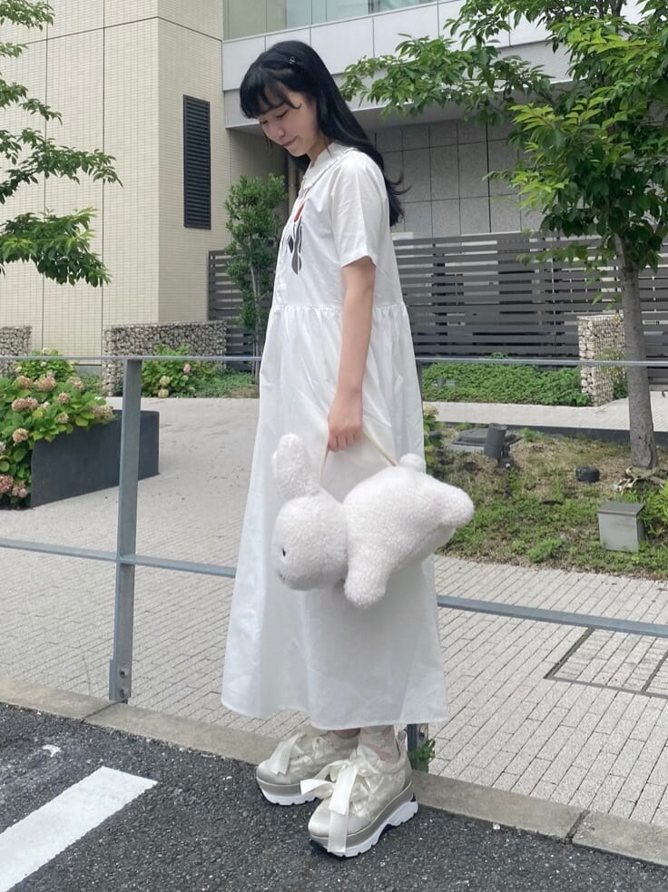 ホワイト系のハンドバッグ、ホワイト系のワンピースを着用したレディースの夏コーディネートの3枚目の写真