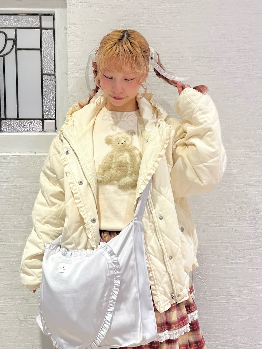 ホワイト系のダウンジャケット/コート、ホワイト系のニット/セーター、ブルー系のショルダーバッグを着用したレディースの冬コーディネートの4枚目の写真