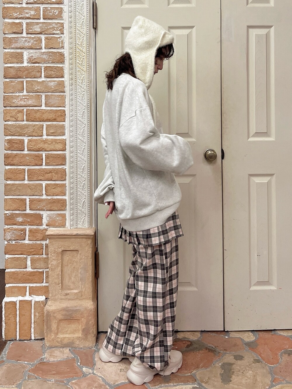 ピンク系のスラックス、グレー系のスウェット、ホワイト系のスニーカーを着用したレディースの夏コーディネートの2枚目の写真