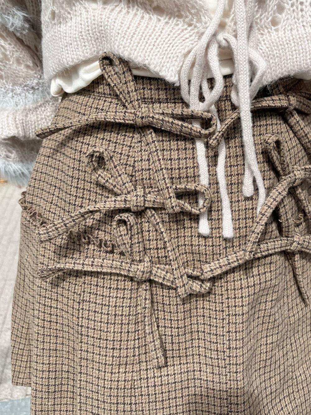 グレー系のカーディガン/ボレロ、ホワイト系のボストンバッグ、ホワイト系のTシャツ/カットソーを着用したレディースの秋コーディネートの7枚目の写真