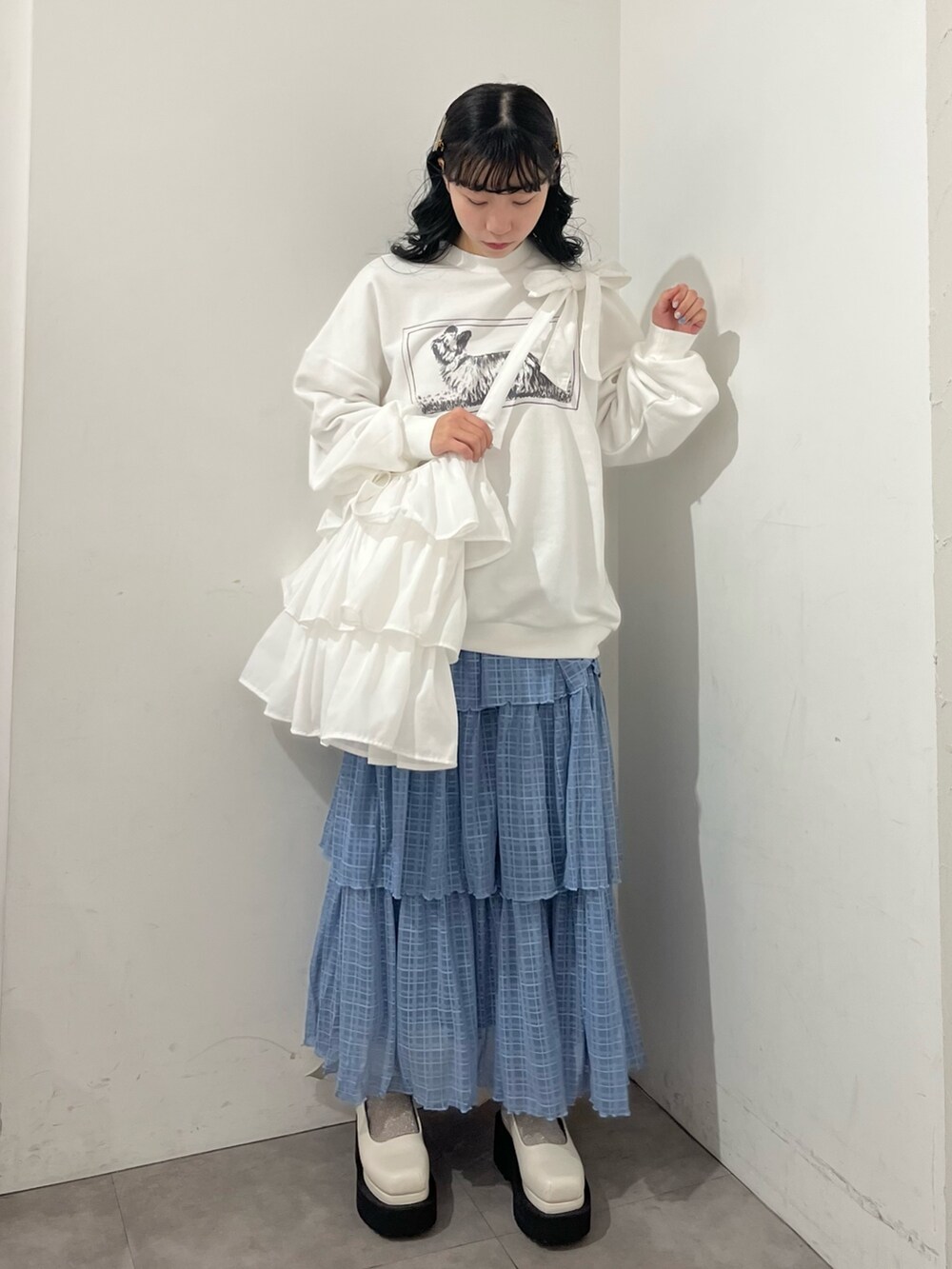 ホワイト系のトートバッグ、ホワイト系のスウェット、ブルー系のスカートを着用したレディースの春コーディネートの2枚目の写真
