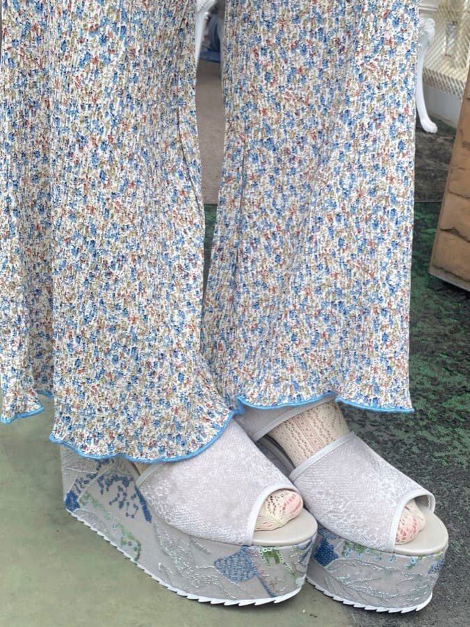 グレー系のサンダル、ホワイト系のチュニック、ブルー系のその他パンツを着用したレディースの秋コーディネートの5枚目の写真