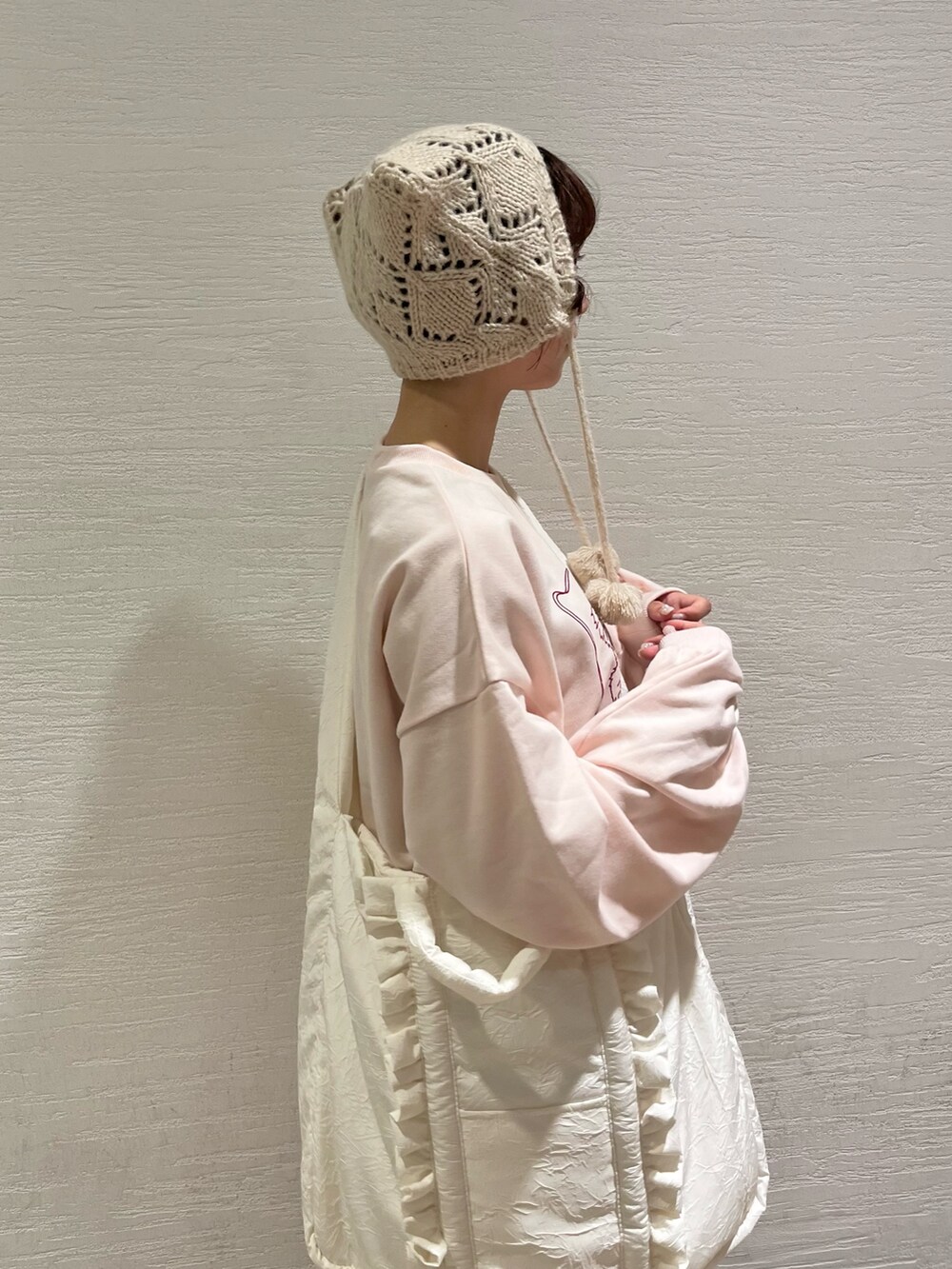 ピンク系のスウェット、ベージュ系のスカート、ホワイト系のトートバッグを着用したレディースの秋コーディネートの6枚目の写真