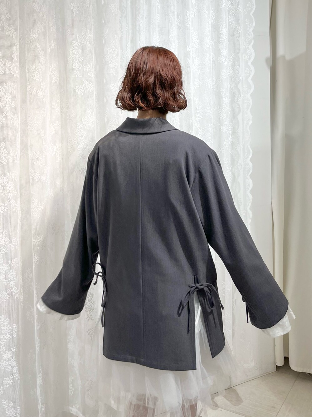 グレー系のテーラードジャケット、ブルー系のTシャツ/カットソー、ホワイト系のワンピースを着用したレディースの冬コーディネートの8枚目の写真