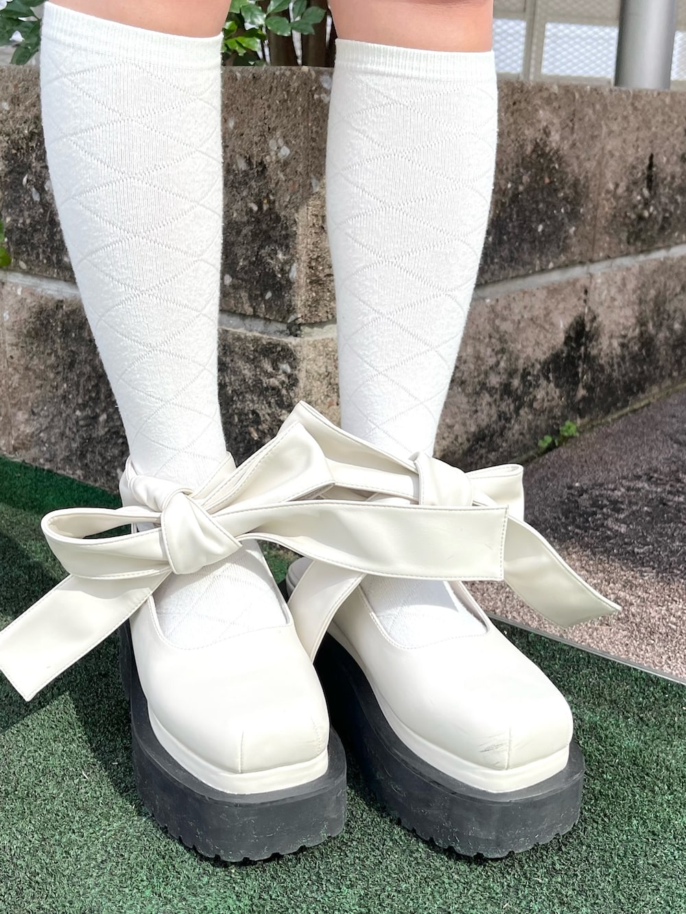 ブルー系のスカート、ホワイト系のパンプス、ブルー系のテーラードジャケットを着用したレディースの春コーディネートの5枚目の写真