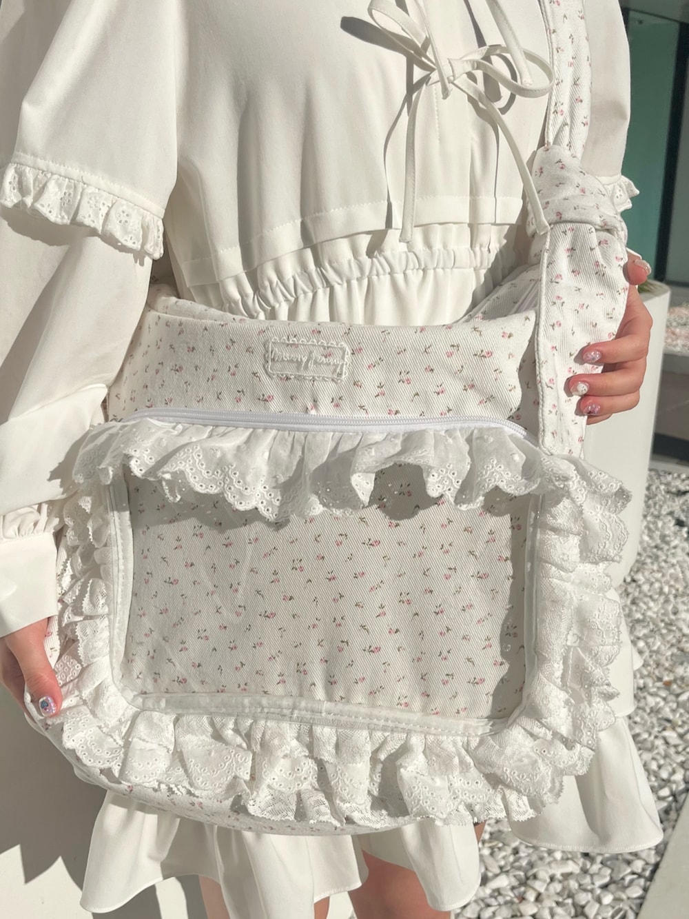 ホワイト系のワンピース、ピンク系のショルダーバッグ、ホワイト系のスニーカーを着用したレディースの冬コーディネートの9枚目の写真