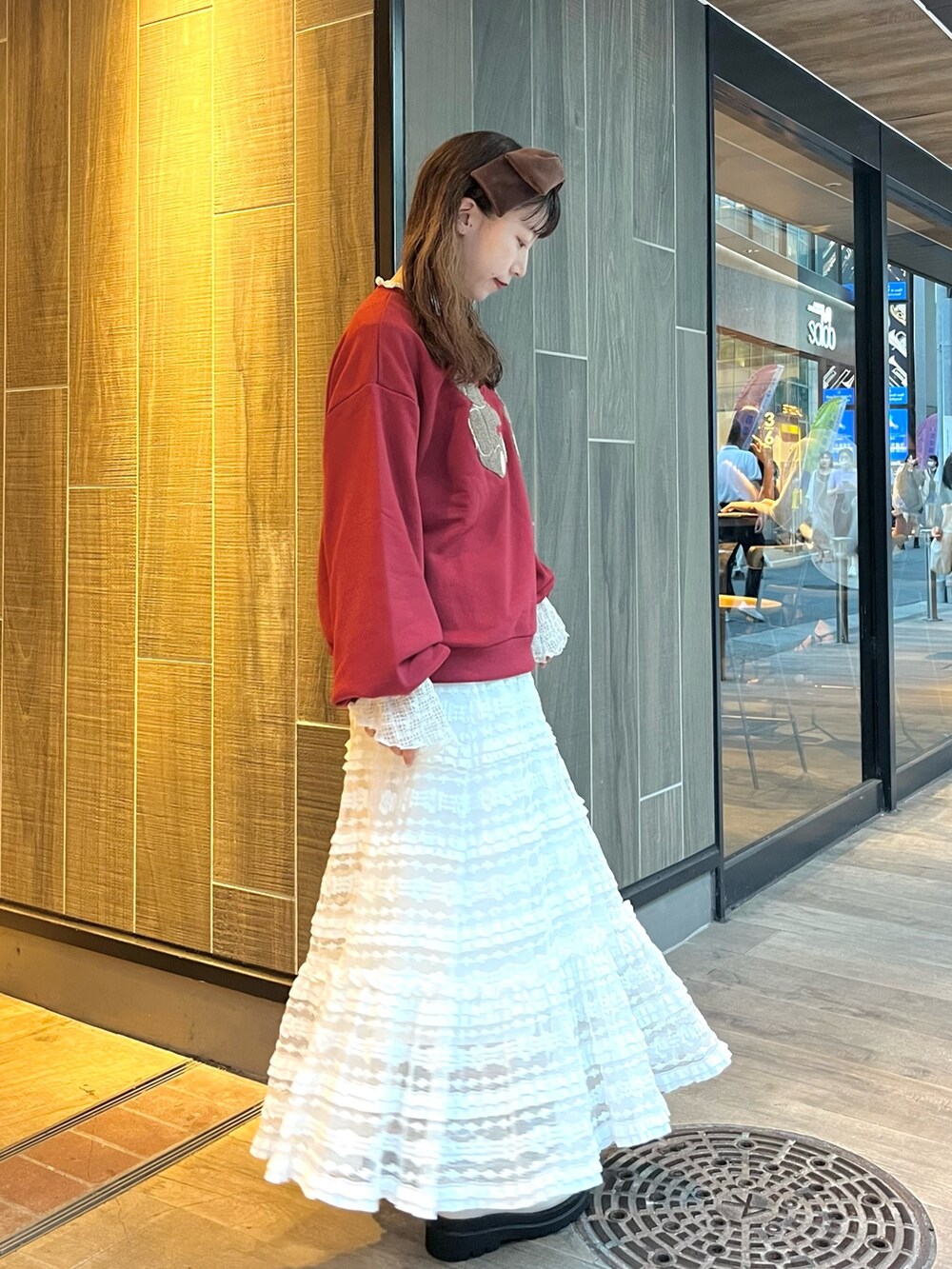 レッド系のスウェット、ホワイト系のTシャツ/カットソー、ホワイト系のスカートを着用したレディースの秋コーディネートの2枚目の写真