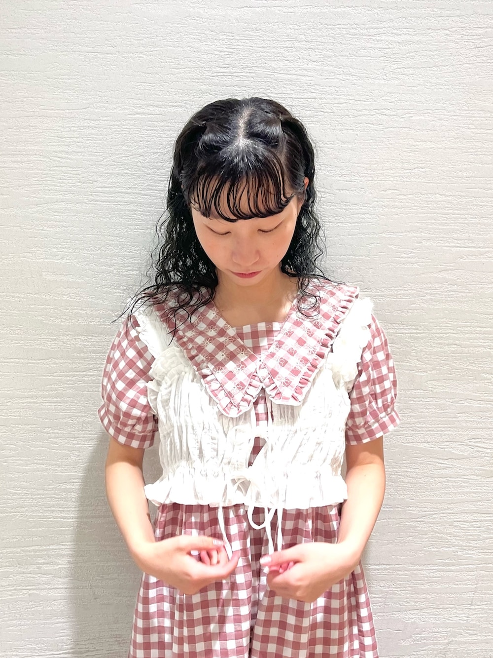 ピンク系のワンピース、ホワイト系のサンダル、ホワイト系のベストを着用したレディースの夏コーディネートの4枚目の写真